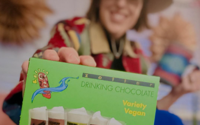 Zotter drinking chocolate held by a smiling woman